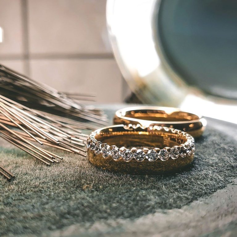 Zwei Eheringe aus Gold, der vordere ist mit Diamanten besetzt