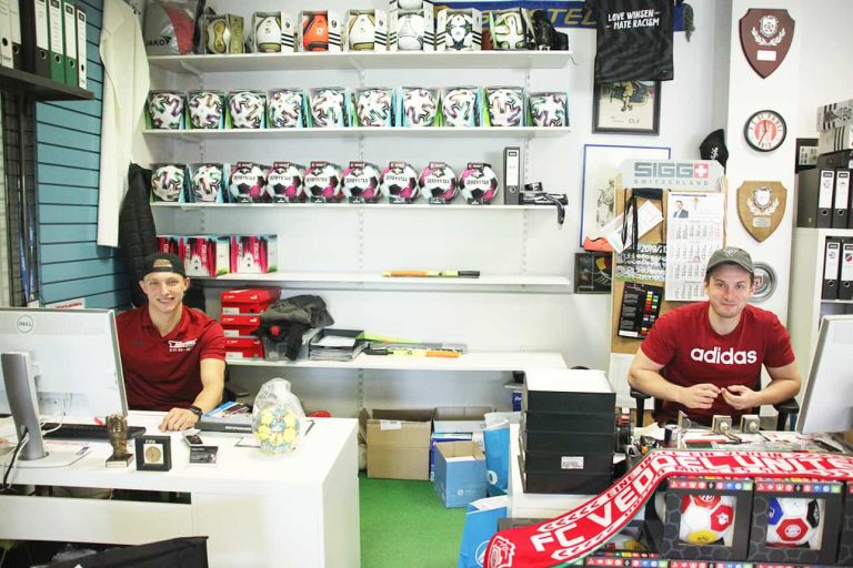Team Sports Jesteburg bei der Arbeit vor Wand mit Fußbällen